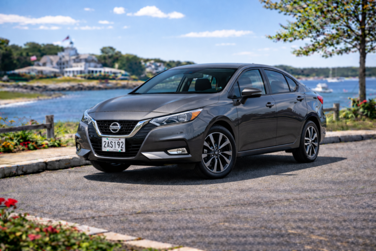 Gray Nissan Versa rental from Vachon in Cranston, RI, shown with a waterfront backdrop